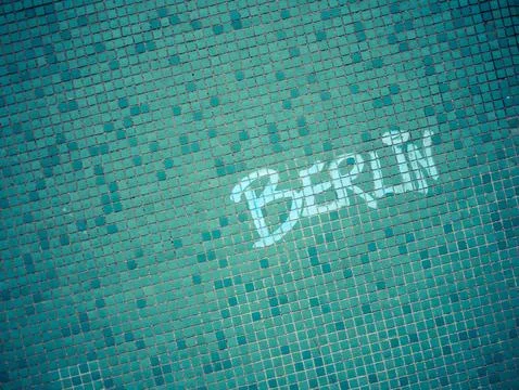 On one wall of the building, which is covered in small turquoise tiles, is th Stock Photos