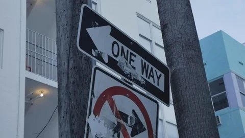 One Way Road Signage in Miami Beach. Cloudy blue sky during the day. Slow Stock Footage 110769853