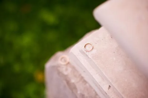 One wedding ring lies on the ledge of the wall and against the background of Stock Photos