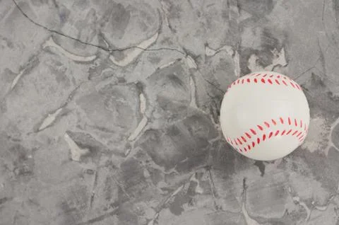 One white and red soft rubber baseball ball on old worn cement. Top view Stock Photos