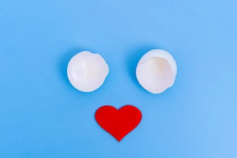 One is a white broken eggshell and a red heart on a blue background. A creati Foto stock