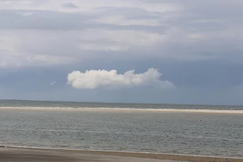 One white cloud at the blue sky above the sea Stock Photos