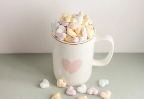 One white cup full of candy hearts Stock Photos