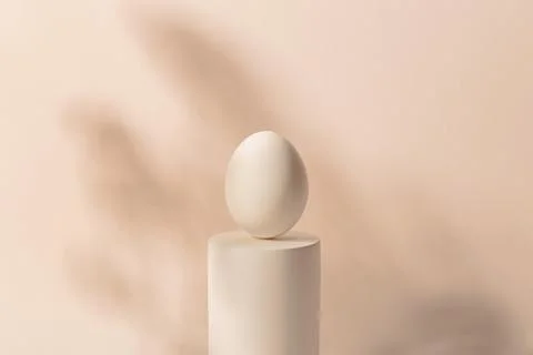 One white Easter egg on a podium against a neutral background. Minimalism and Stock Photos