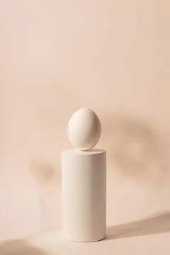 One white Easter egg on a podium against a neutral background. Minimalism and Stock Photos