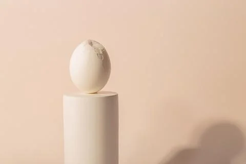 One white Easter egg on a podium against a neutral background. Minimalism and Stock Photos