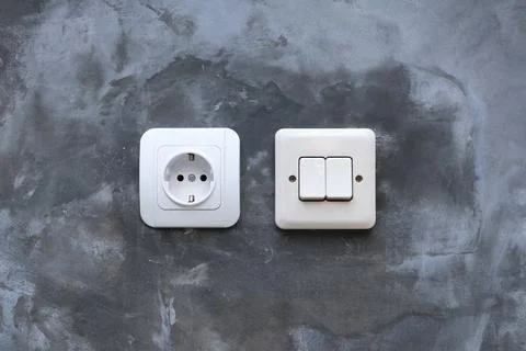 One white electrical power socket and one double light switch mounted on a .. Stock Photos