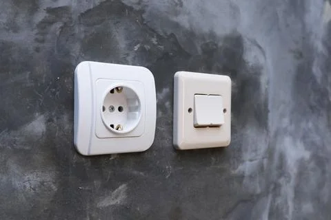 One white electrical power socket and one double light switch mounted on a .. Stock Photos
