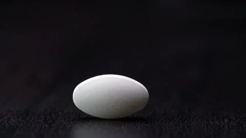 One white tablet is isolated on a black background Stock Photos