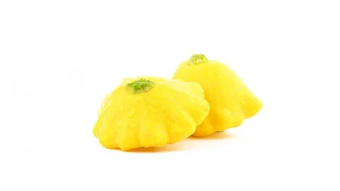 One whole and one half of yellow patisson squashes with water drops. Rotating Stock Footage 98178487