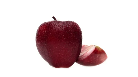 One whole and one slice of red fleshed apple with water drops. Rotating. Stock Footage 169753362
