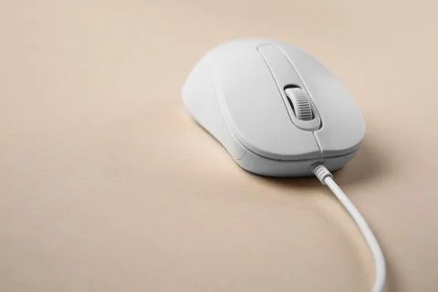 One wired mouse on beige background, closeup. Space for text Foto stock