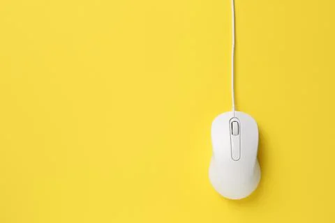 One wired mouse on yellow background, top view. Space for text Foto stock