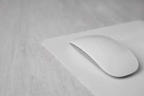 One wireless mouse with mousepad on grey wooden table, closeup. Space for tex Foto stock