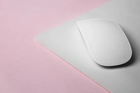 One wireless mouse with mousepad on pink background, closeup. Space for text Foto stock