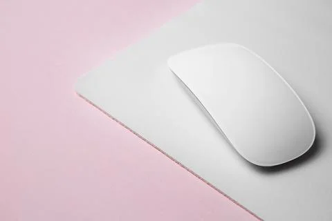 One wireless mouse with mousepad on pink background, closeup. Space for text Foto stock