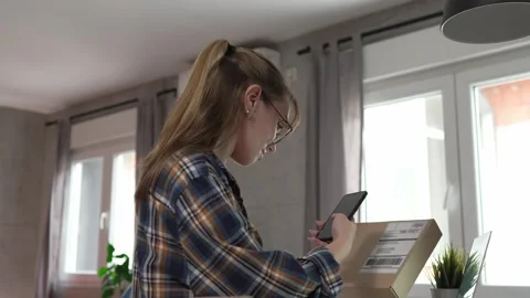 One woman checking box of received package or product at home Stock Footage 249458167
