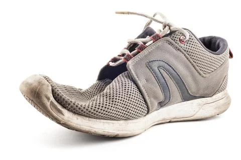 One worn out sneaker isolated on white background 库存照片