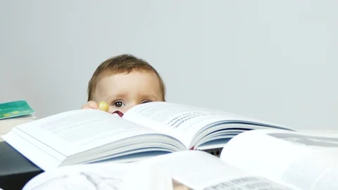 A one year age cute baby drops books. Stock Footage 101360710