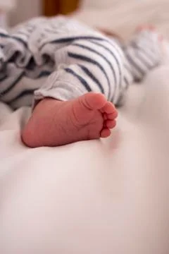 One year old baby"s barefoot in bed. Stock Photos