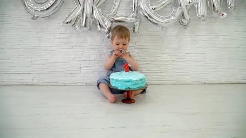 One-year-old boy eating cake on his first birthday, happy infant baby celebratin Vídeos de archivo 299739452