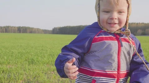 One year old boy goes in the field with young wheat Video stock 89638130