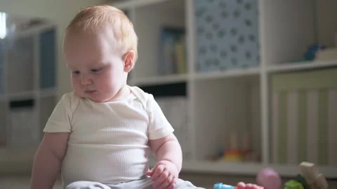 One year old boy plays in the child's room with montessori tower, raises his  Video stock 273438397