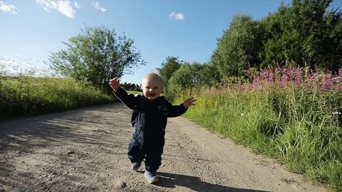 One year old boy is running by the sandy road and laughing. Stock Footage 78487616