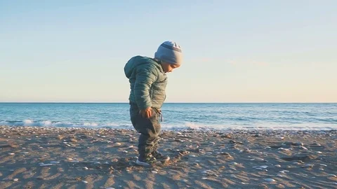 A one year old boy runs and is played on the beach near the sea 스톡 동영상 84760770