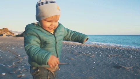 A one year old boy runs and is played on the beach near the sea 動画素材 84761544