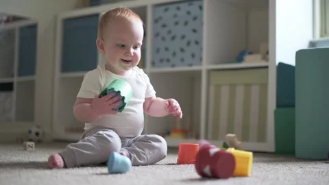 One year old boy  sitting on the floor play in the child's room with montesso Stockbeeldmateriaal 272718660