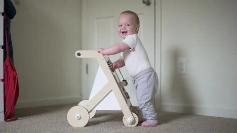A one year old boy standing carefully in the room plays with a montessori edu Vídeo Stock 272718721