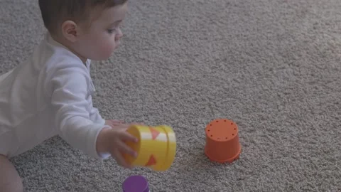 One year-old child playing with educational cup toys at home. Little baby boy Video stock 163310193