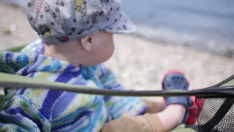 One-year-old child sitting in a tourist chair Видео 90174933