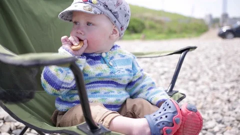 One-year-old child sitting in a tourist chair Видео 90174959
