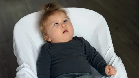 One year old disabled child is upset in baby swing Stock Footage 101779395