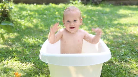 One year old kid having a bath outdoors Stock Footage 53208323