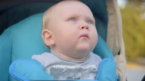 One years old baby boy sneezing in the pram. Close-up. Slow Motion Stock Footage