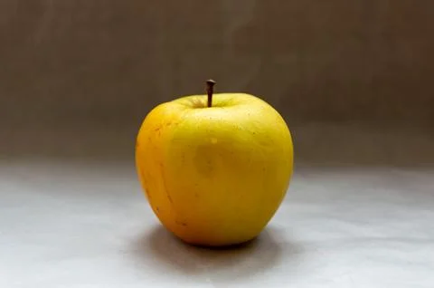 One yellow apple on the table Stock Photos