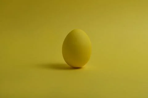 One yellow painted Easter egg stand on a yellow background. Stock-Fotos