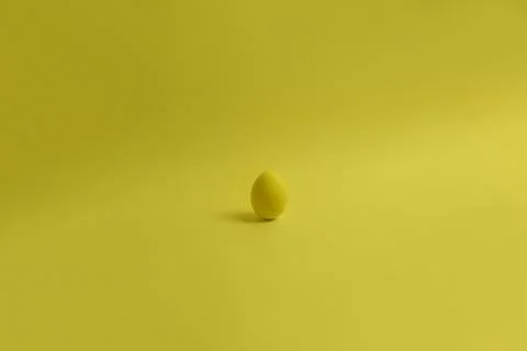 One yellow painted Easter egg stand on a yellow background. Stock-Fotos