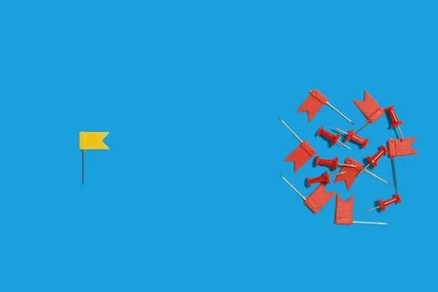 One yellow pin flags lying against many red pushpins Stock Photos