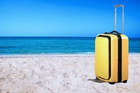 One yellow suitcase on sandy beach near sea. Space for text Stock-Fotos