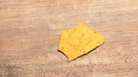 One yellow triangular nachos are eaten stop motion timelapse. Fast food and high Stock Footage 125766475