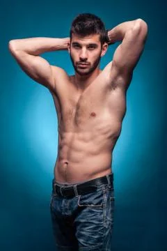 One young adult man, shirtless body, arms raised Stock Photos