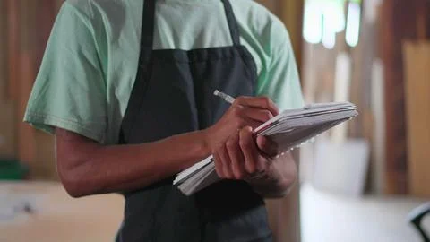 One Young Black Brazilian Apprentice of Carpentry Workshop Taking Notes on .. Stock Photos