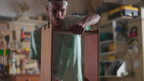 One young black carpenter apprentice working at carpentry workshop building.. Foto stock