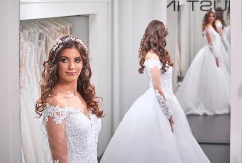 One young bride, looking at self, wearing gown, in mirror image back, front v Stock Photos