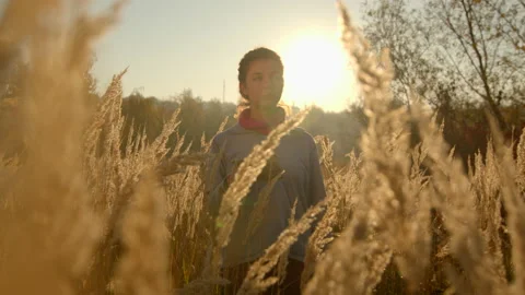 One young girl looking into a map, wearing fleece sweater, standing in spikelets Stock Footage 167337837