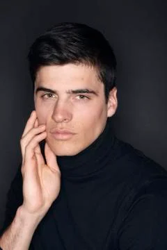 One young handsome man, model wearing turtleneck, simple studio upper body sh Stock Photos